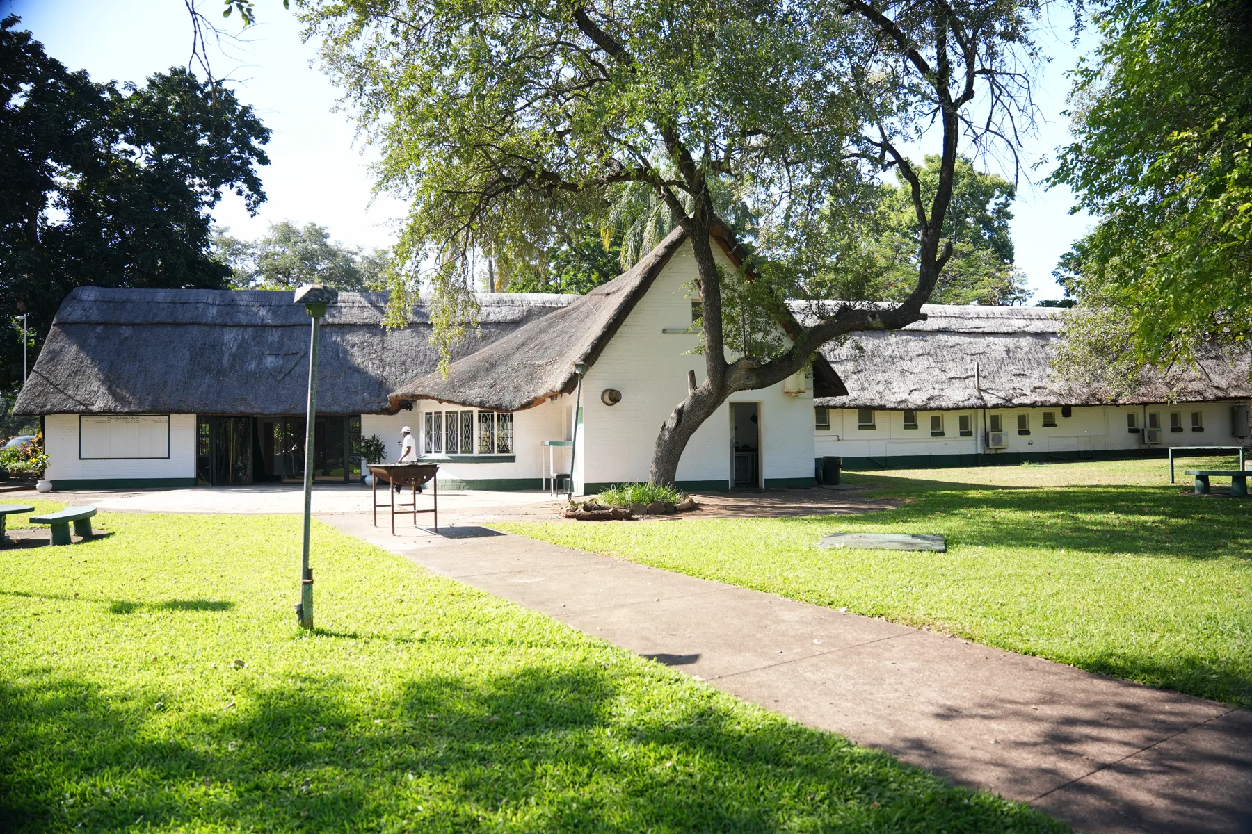 The thatched Triangle clubhouse framed by mature trees